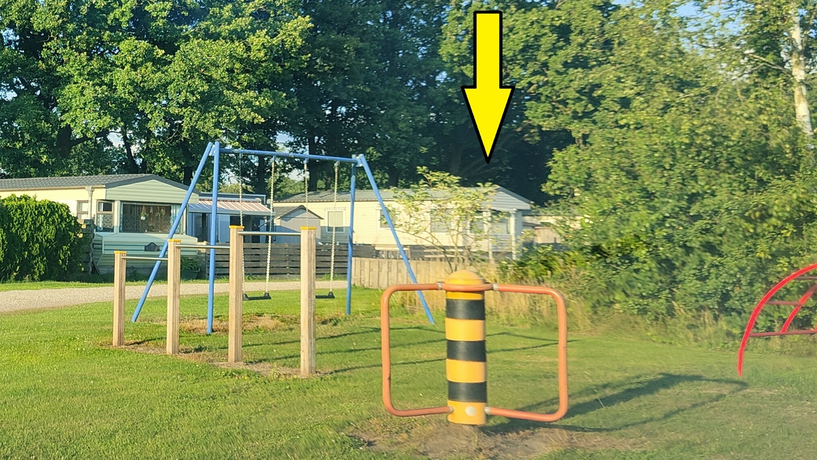 Klein speeltuintje met caravan erachter